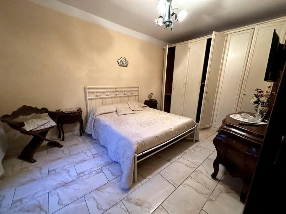 1 dormitorio con cama blanca y piano en Casa Felice, en Cercola