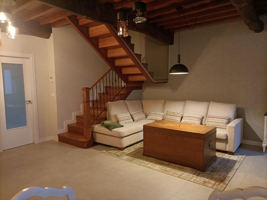 a living room with a white couch and a wooden table at Casa a Antiga Tenda in Santiago de Compostela