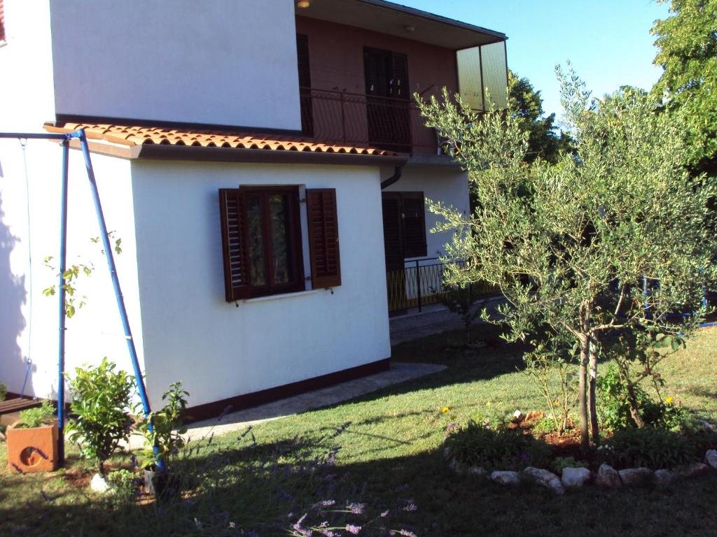 mały biały dom z oknem i drzewem w obiekcie Apartment Gogo w mieście Umag