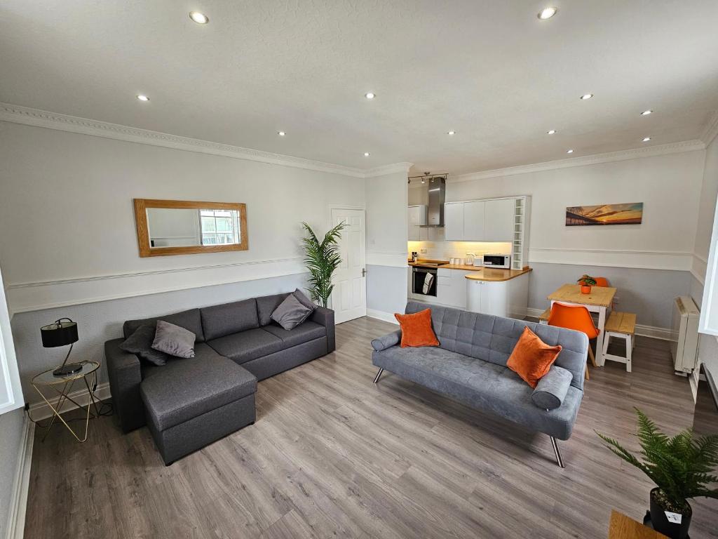Una sala de estar con dos sofás y una cocina. en Lakeview Apartment, central location, Sea and Lake view, free parking & WiFi, en Southport