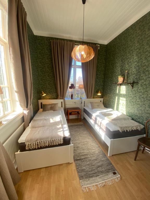 1 dormitorio con 2 camas y ventana en Klostergårdens Vandrarhem, en Varnhem
