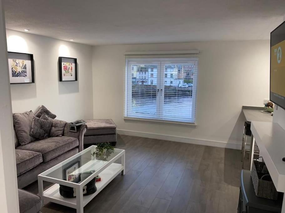 un soggiorno con divano e tavolo di Stunning Refurbished 1 Bedroom, Harbour Apartment. ad Ayr