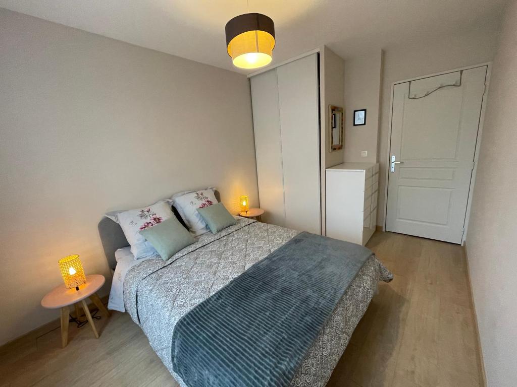 a bedroom with a bed with two lamps and a door at Appartement moderne cœur des châteaux de la Loire - Parking in Blois