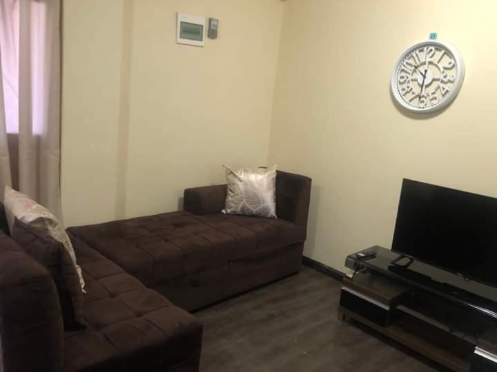 ルサカにあるLouieVille Apartmentsのリビングルーム(ソファ、薄型テレビ付)