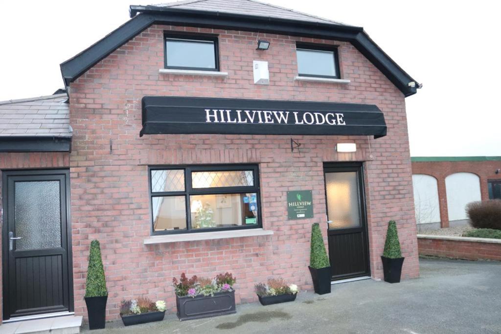 un edificio de ladrillo con un letrero que lee "Hurdley Lodge" en Hillview Lodge, en Armagh