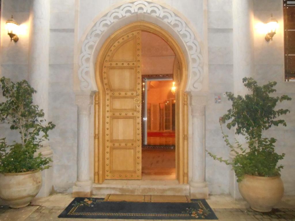uma entrada para um edifício com uma porta de madeira em Dar Nador em Nador