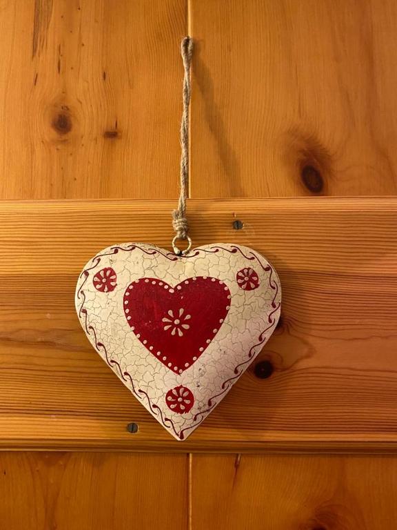 a heart ornament hanging on a wooden wall at Fiordaliso in Santo Stefano dʼAveto