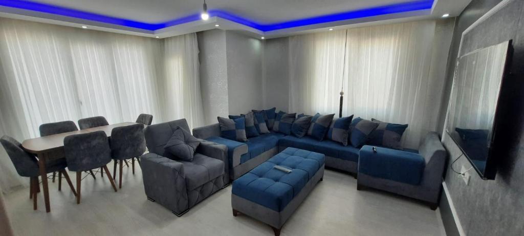 Cette chambre comprend un canapé, une table et des chaises. dans l'établissement omar, à Basaksehir