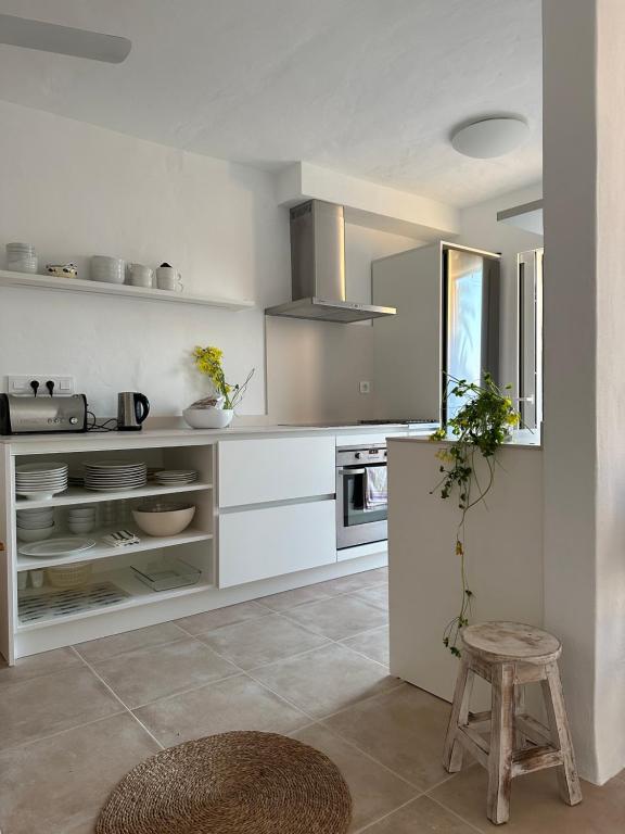 a kitchen with white cabinets and a stool in it at Duplex Son Parc Best Sea Views in Son Parc