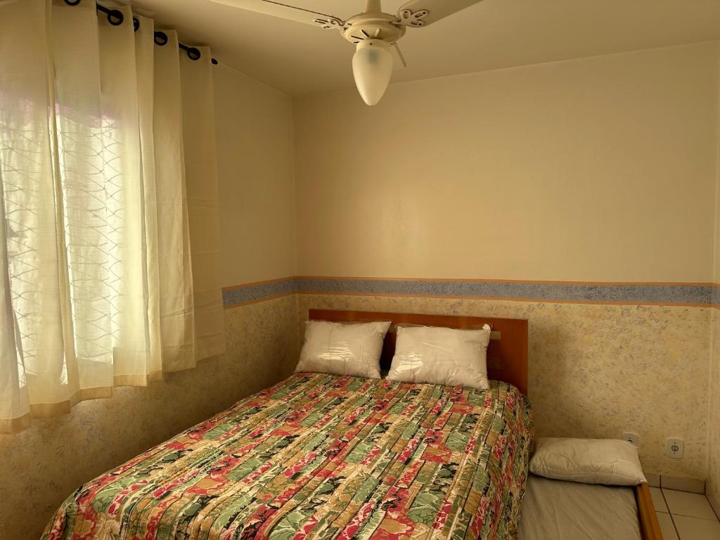 1 dormitorio con 1 cama y ventilador de techo en Água das Fontes, en Caldas Novas