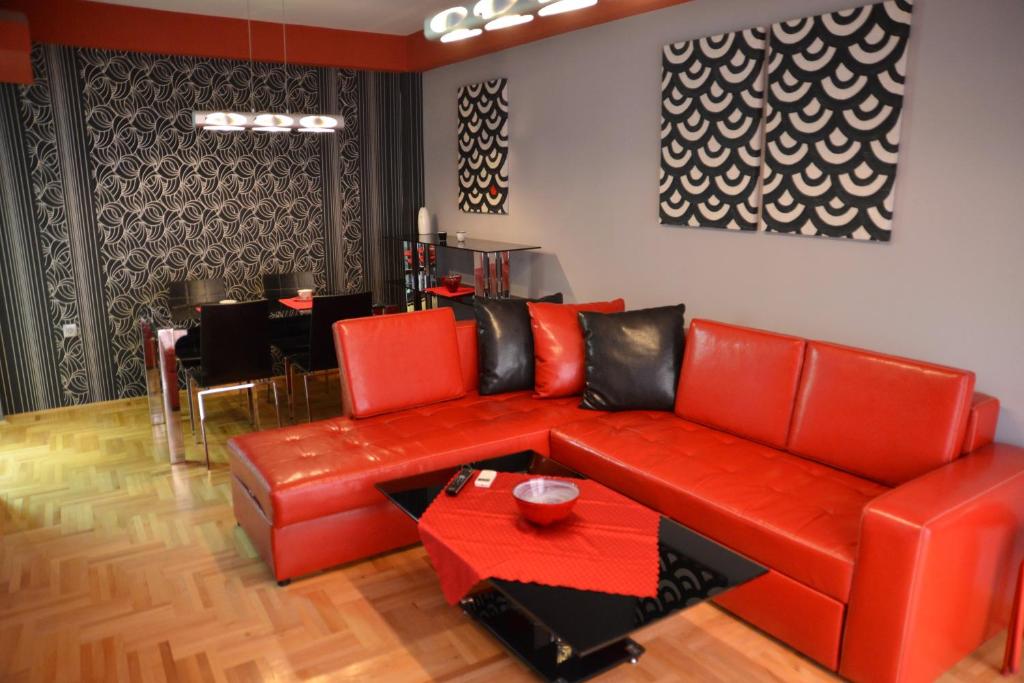 a living room with a red couch and a table at Korali Apartment in Ohrid