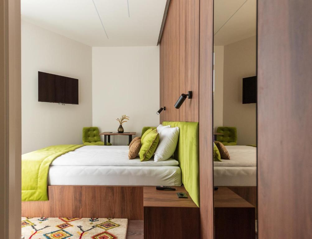 a bedroom with two beds and a mirror at Apartments EMERALD Free Garage Parking in Sarajevo
