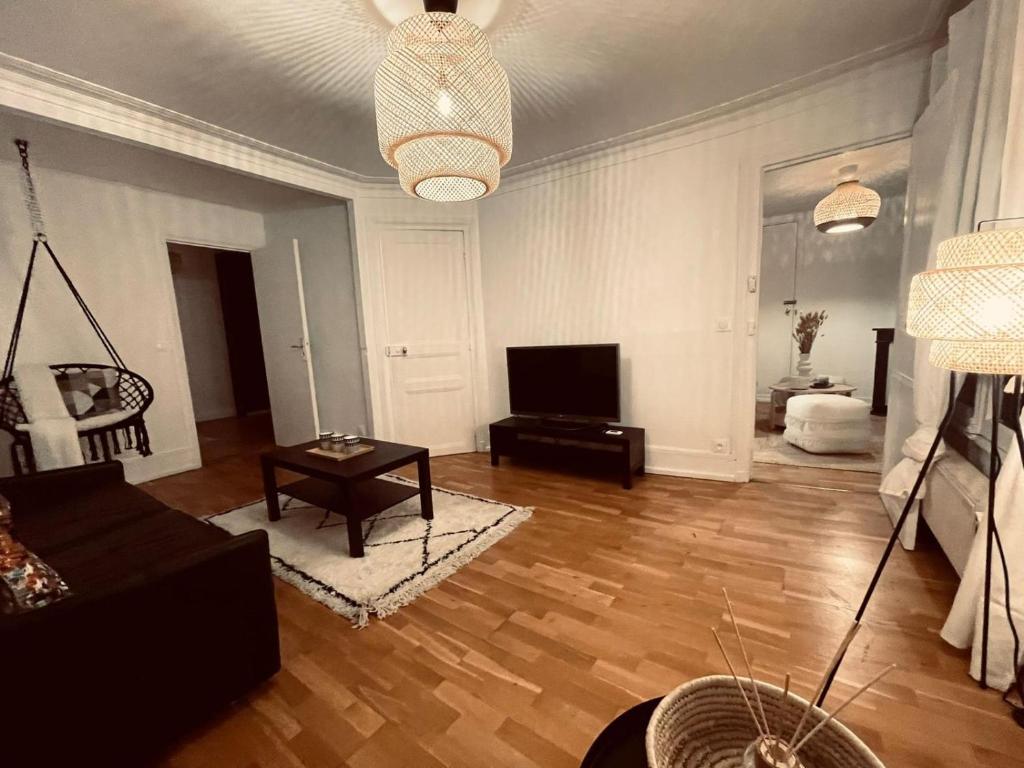 Chic Apartment on the famous shopping Rue du Faubourg Saint-Honoré street في باريس: غرفة معيشة بها أريكة وتلفزيون