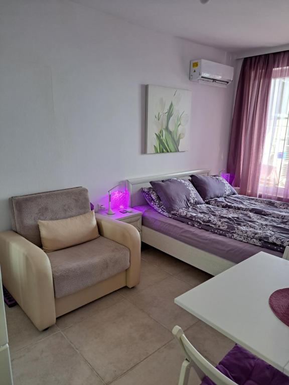 ein Wohnzimmer mit einem Bett und einem Stuhl in der Unterkunft Stensi Atlantis studia in Rawda