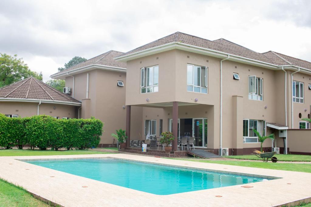 una casa con piscina frente a ella en Krisstar Lodge en Blantyre
