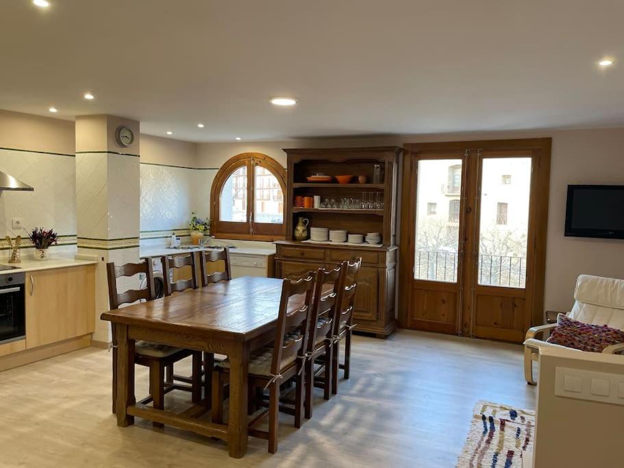 a kitchen with a wooden table and a dining room at Morella, confort y excelentes vistas Casa Joanes in Morella