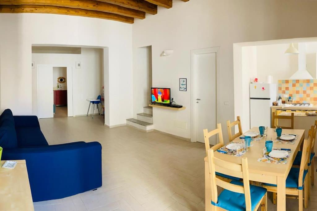 Casa Gigé في أوستيكا: غرفة معيشة مع طاولة وأريكة زرقاء