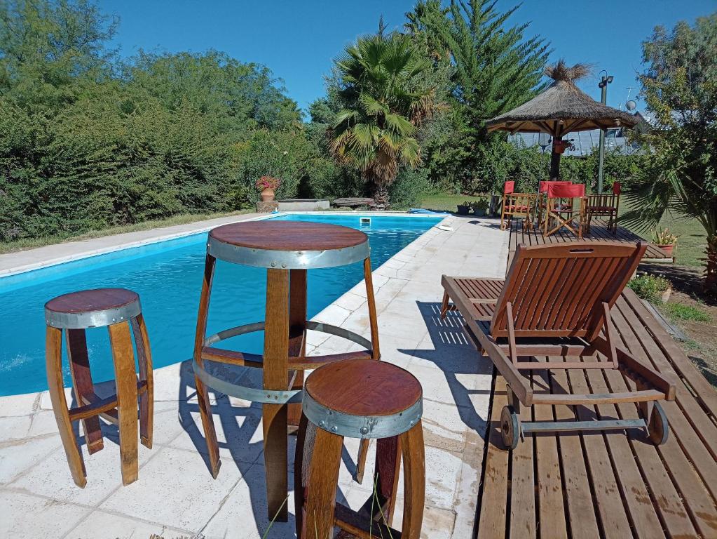 un patio con sillas y una mesa y ools junto a una piscina en Quinta Los Olivos en Maipú