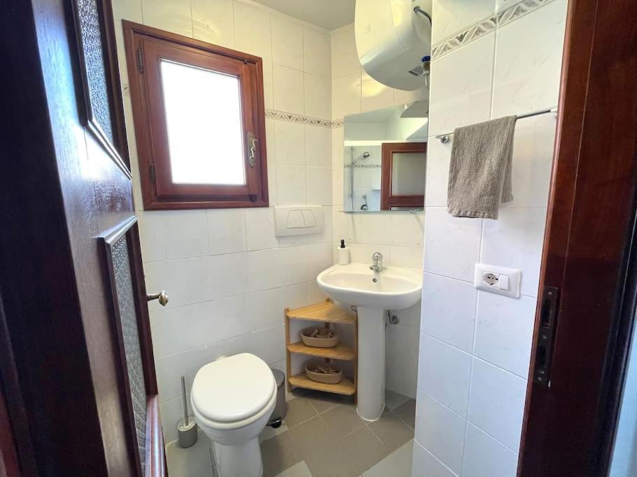 a white bathroom with a toilet and a sink at Historic Downtown Home By The Sea With King Bed in Monterosso al Mare