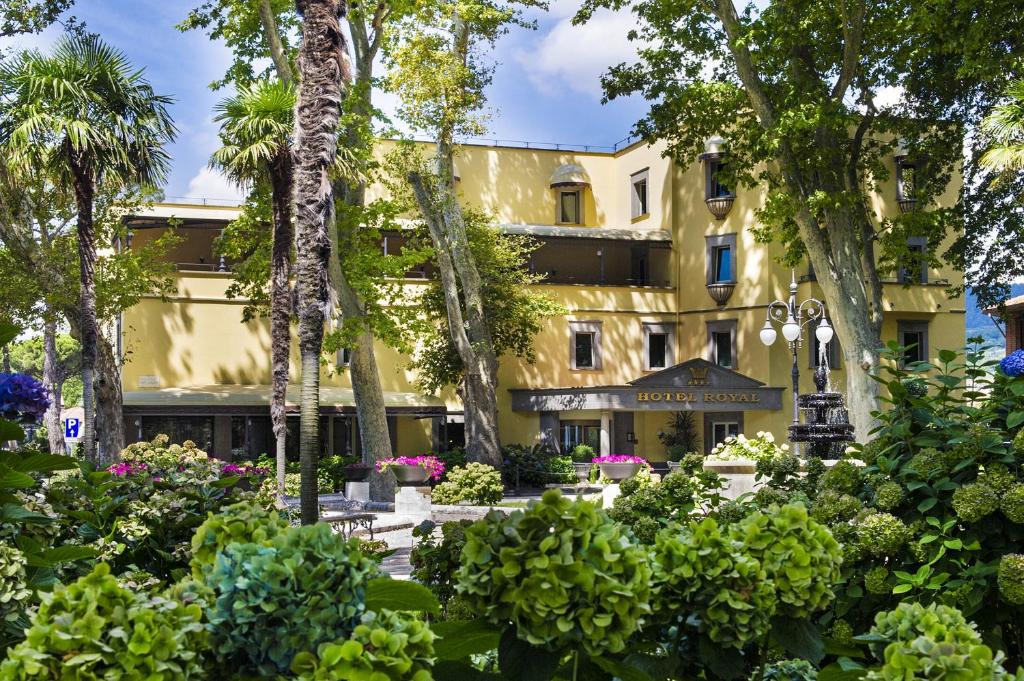 un hotel con jardín frente a un edificio en Hotel Royal, en Bolsena