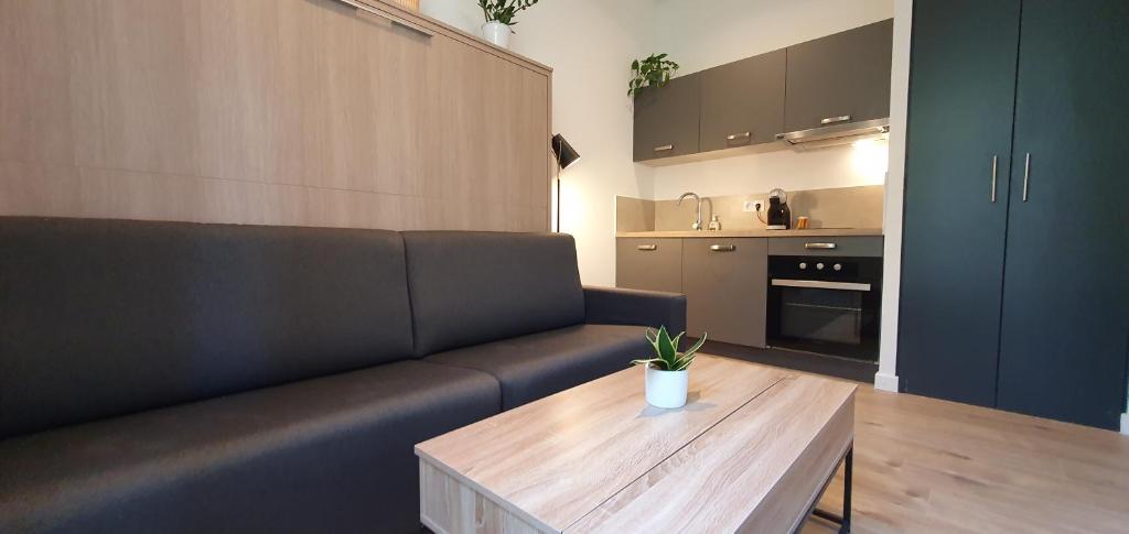 un salon avec un canapé et une table en bois dans l'établissement VALROSE, à Nice