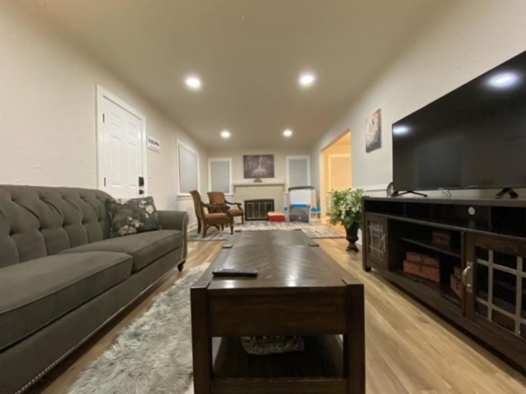 a living room with a couch and a flat screen tv at Charming Brick Home with bonus space & foosball in Spokane