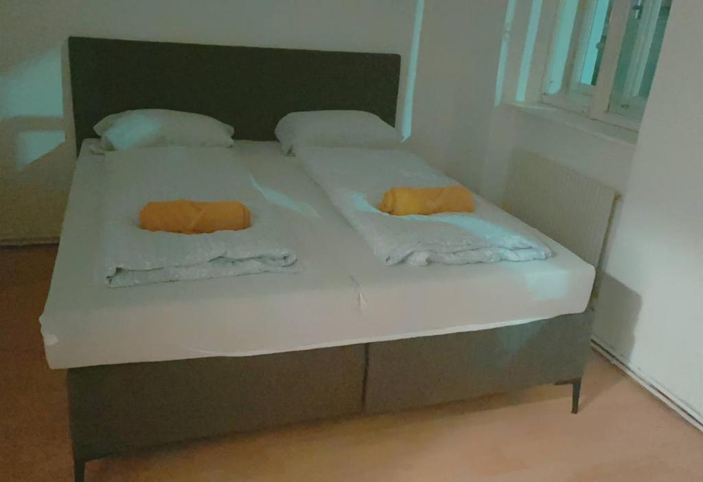 a bed with white sheets and orange pillows on it at Standard Apartment 5P TH in Vienna