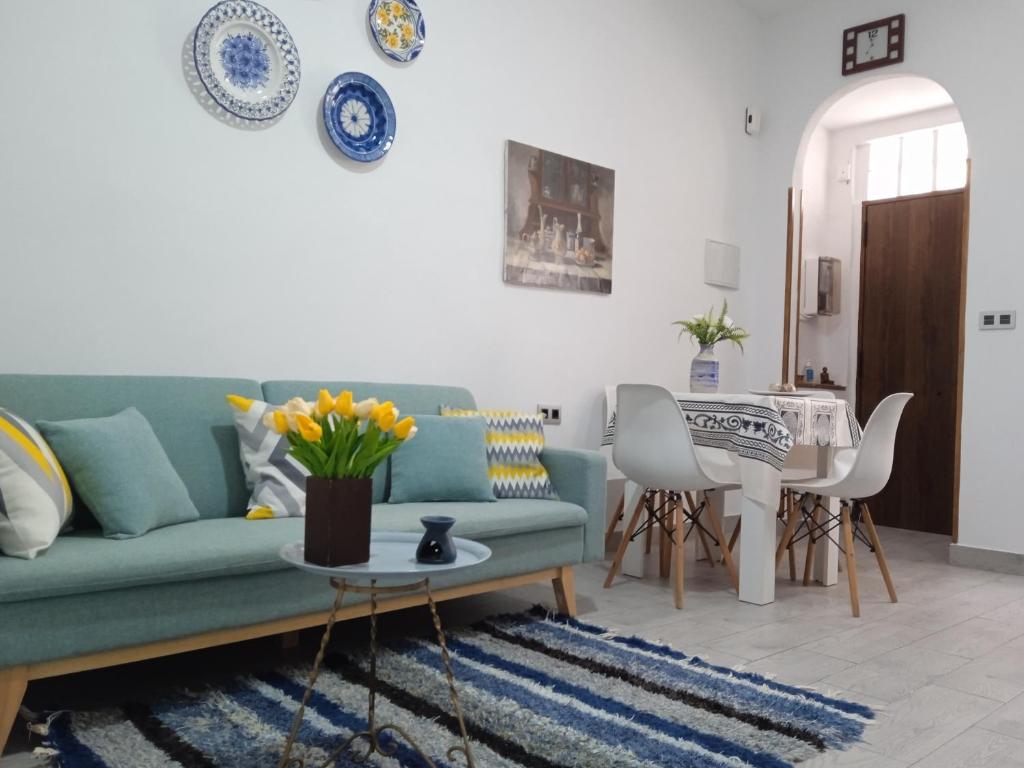 a living room with a green couch and a table at Apartamentos Lax in Almería