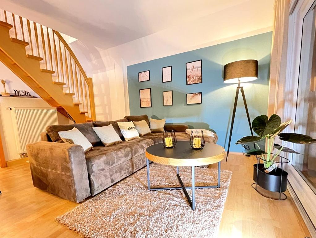 a living room with a couch and a table at Familienfreundliches Ferienhaus in 5 min zum Strand mit Terrasse und kostenlosem Parkplatz in Cuxhaven
