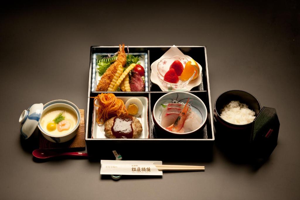a tray of food with chopsticks and bowls of food at Jizokan Matsuya Ryokan in Nagano