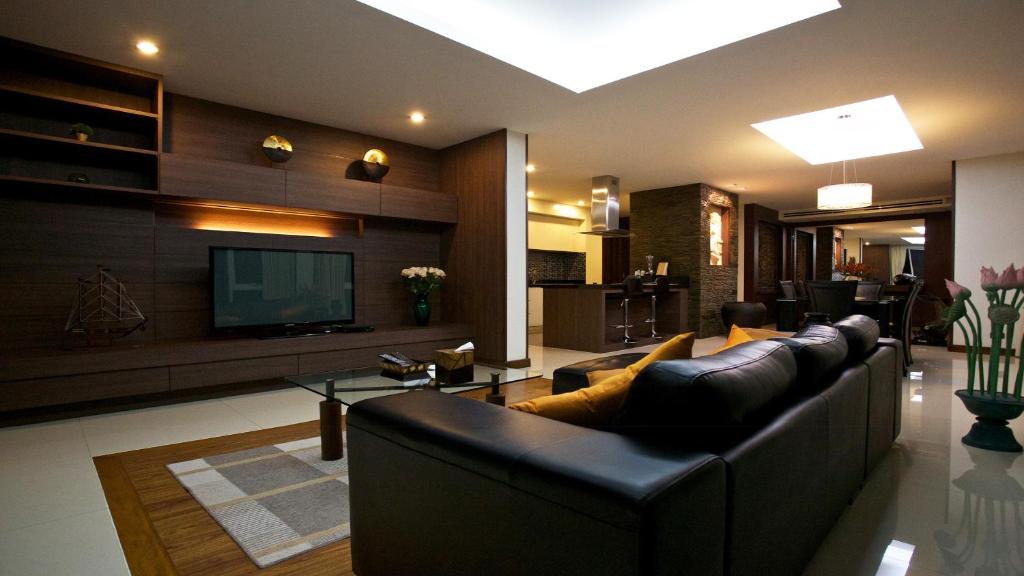 sala de estar con sofá y TV en Karon Suite Apartment, en Karon Beach