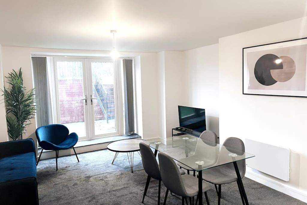 a living room with a glass table and chairs at Lovely 2-BR Flat near Salford Royal in Manchester