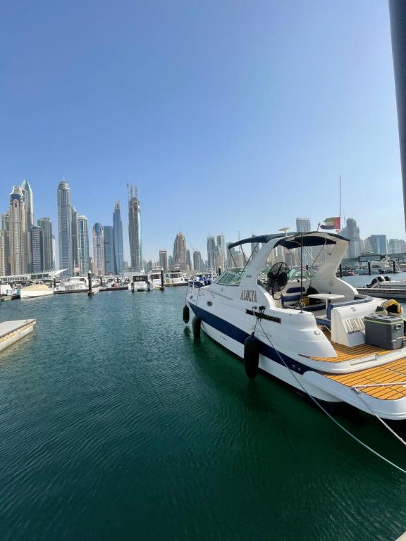 Biała łódź zacumowana w porcie z miastem w obiekcie Yacht( boat )2 Beds, 1 Bath Dubai Eye Marina JBR w Dubaju