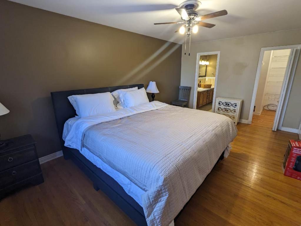 a bedroom with a large bed with a ceiling fan at Lovely Place in Kingston