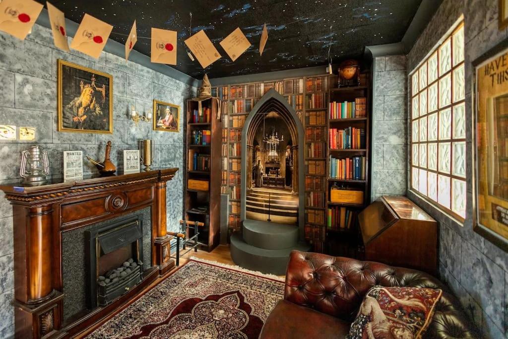 un soggiorno con camino e librerie di Hogwarts Hideaway Themed Property a Garston