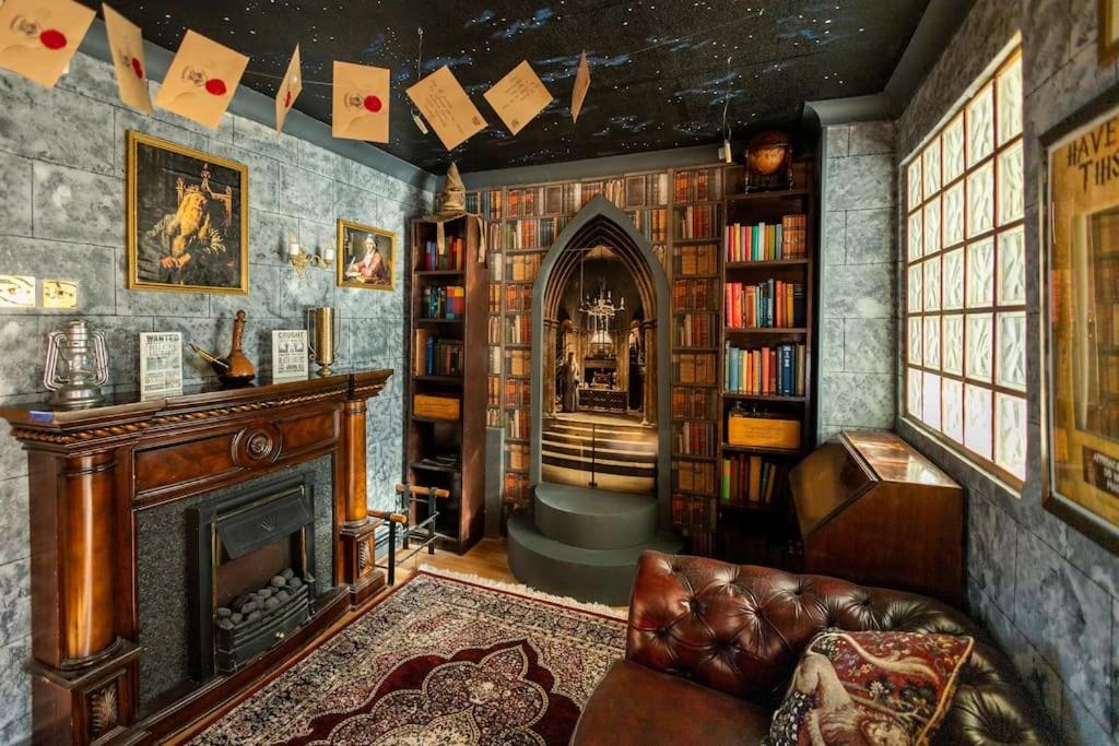 a living room with a fireplace and book shelves at Hogwarts Hideaway Themed Property in Garston