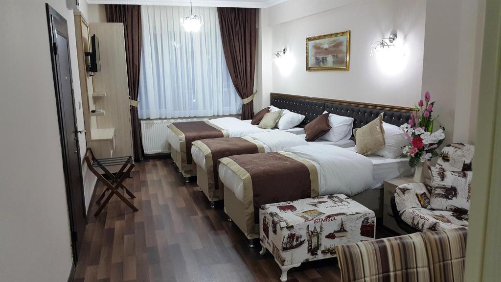 イスタンブールにあるバヤズィトハン スイーツのベッド2台とソファが備わるホテルルームです。