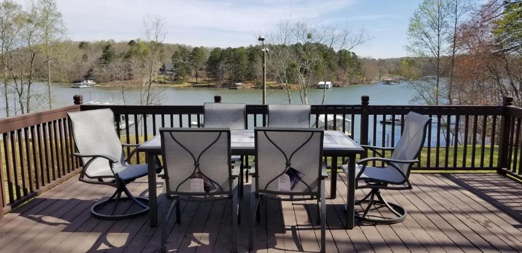 a table and chairs on a deck with a view of a lake at Pine Haven Lake front home /w Dock in Murrayville