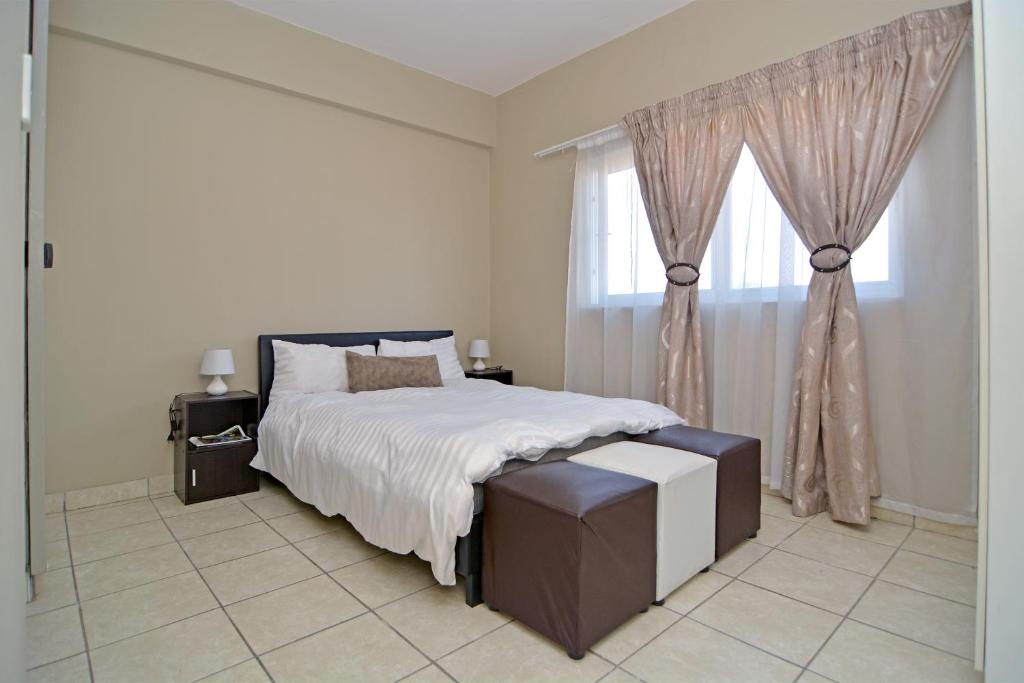- une chambre avec un grand lit et une fenêtre dans l'établissement The Westpoint -Modern ,secure apartment, à Roodepoort