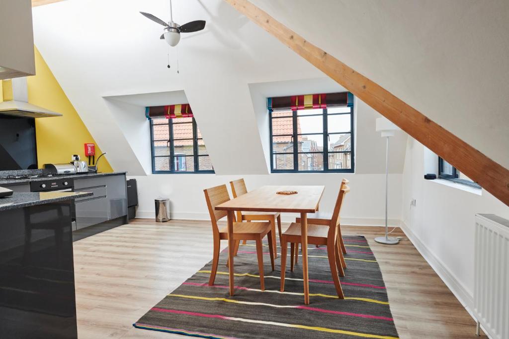 a kitchen and dining room with a wooden table and chairs at The Penthouse in King's Lynn