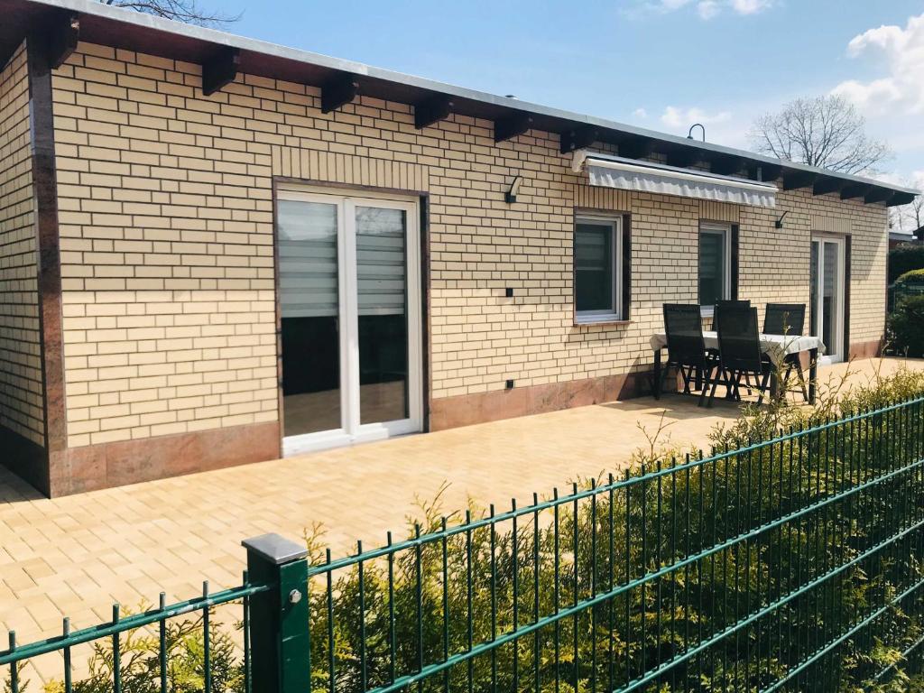 a brick house with a patio and a table at Ferienhaus Live Deluxe in der schönen Uckermark in Meyenburg