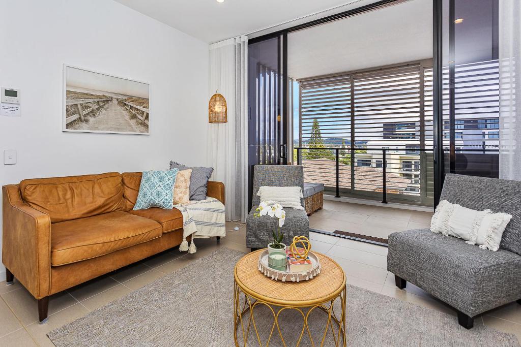 a living room with a couch and chairs and a table at Coastal Souls North Kirra Beach in Gold Coast
