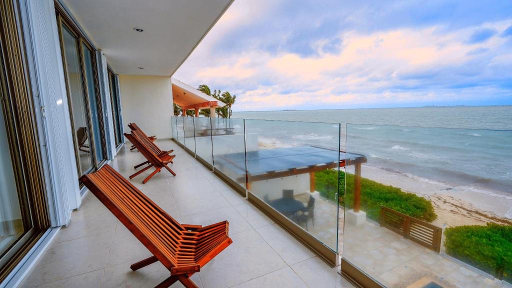 a balcony with a table and a view of the ocean at Villa Coral Ocean Front Progreso in Progreso