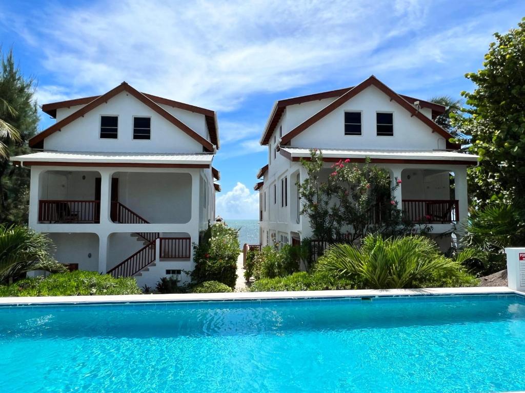 a house with a swimming pool in front of it at VeLento Partial Ocean View #6 in Caye Caulker