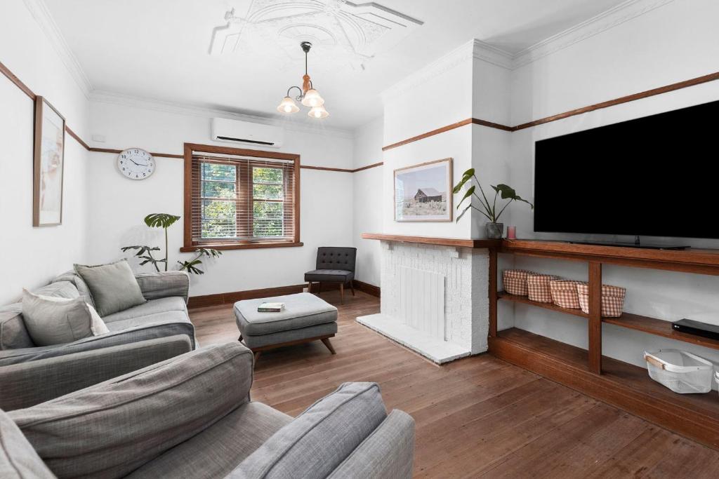 uma sala de estar com televisão e lareira em Charming Cottage Escape - Pet friendly! em Geelong West
