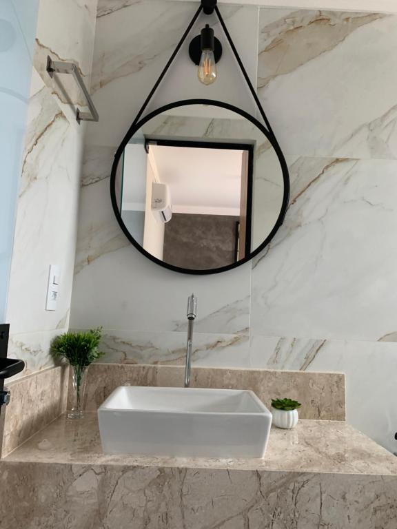 a bathroom with a white sink and a mirror at Pousada Família Bueno in Monte Alegre do Sul