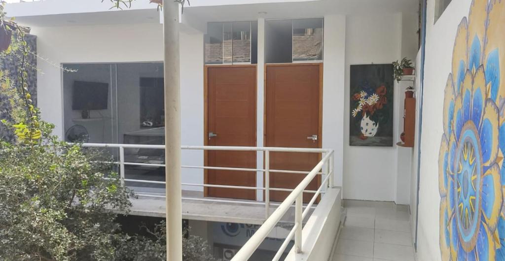 uma casa com portas castanhas ao lado dela em Edificio Sánchez Cerro em Piura