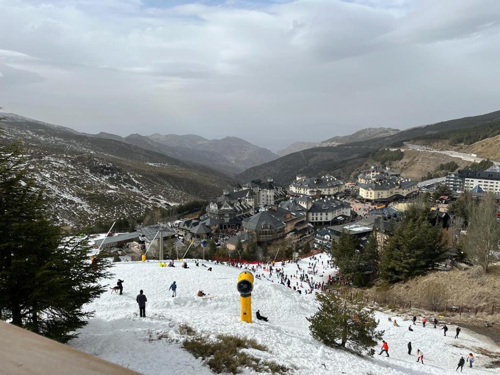 a group of people skiing down a snow covered slope at MARIBEL ELITE in Sierra Nevada