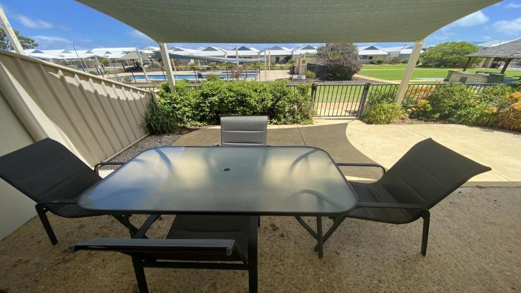 a glass table and two chairs on a patio at Unit 48 Seafront Estate in Jurien Bay