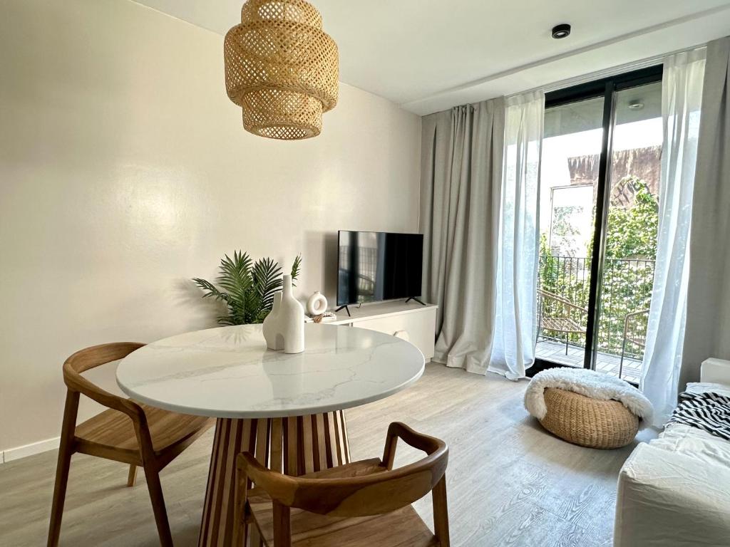 Habitación blanca con mesa, sillas y cama en Hermoso departamento en Palermo Soho en Buenos Aires